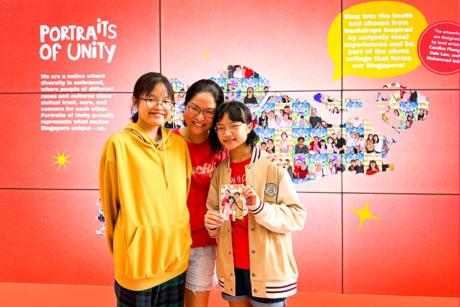 A mother and her daughters with their instant portrait from the Portraits of Unity station