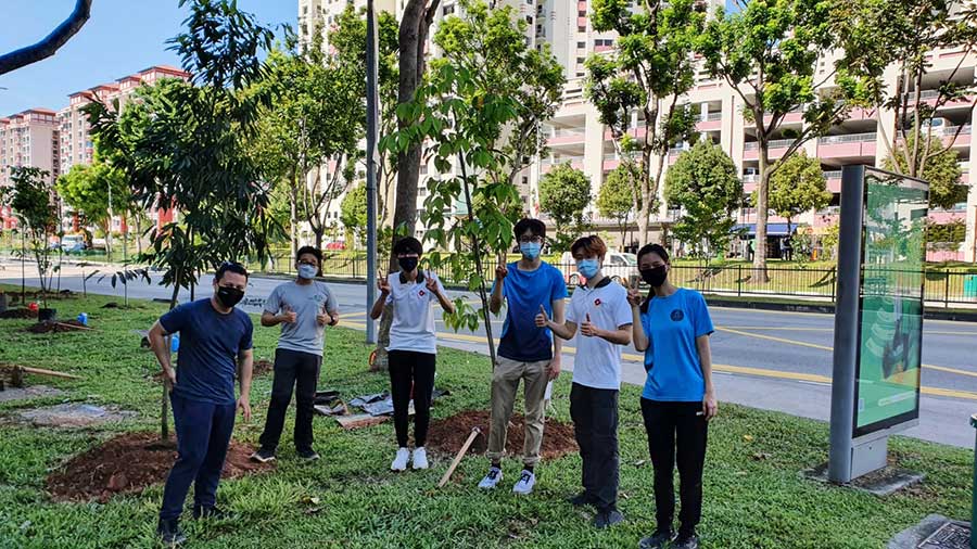 Minister for National Development Desmond Lee and Joshua, planting trees with OneMillionTrees volunteers.